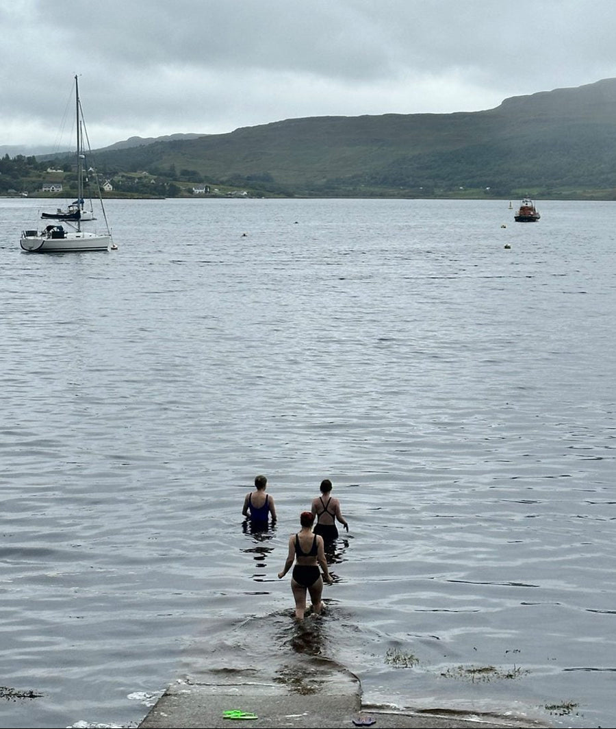 Women wild swimming in a sea loch on the Isle of Skye